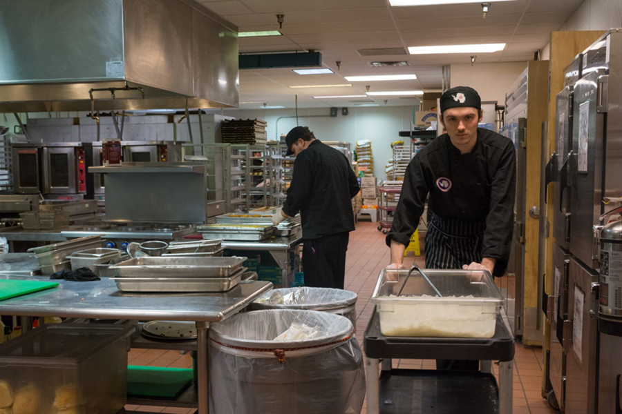 Devin Reid pushes a trolley with rice through McMurdo Station's kitchen. Each day the kitchen staff prepare meals for up to almost 1,000 people working on the station