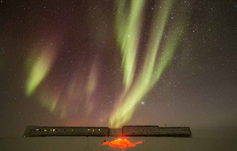 The igloo glows in front of the Amundsen-Scott South Pole Station and under the colorful aurora australis