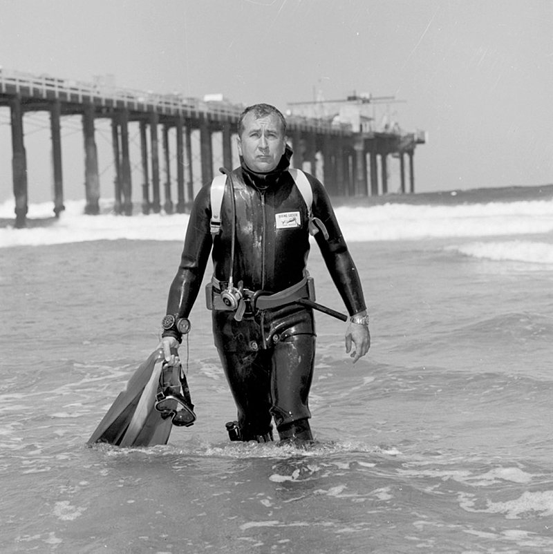 Stewart, wearing his scuba equipment, emerges from the ocean