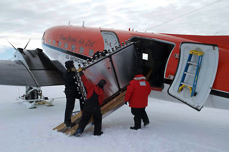People load object into an airplane.