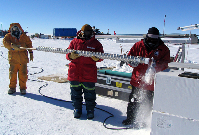 Scientists handle an ice core in Antarctica.