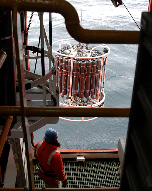 Instrument dangles over water from cable.