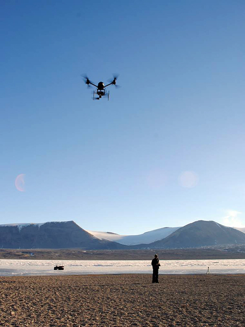 Person operates remote-control helicopter.