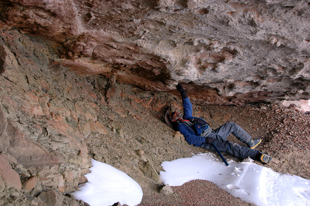 Person examines rock above.