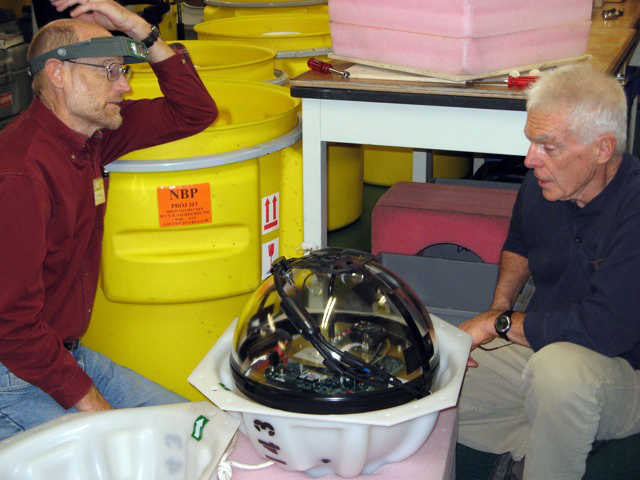 Scientists inspect an oceanographic instrument.