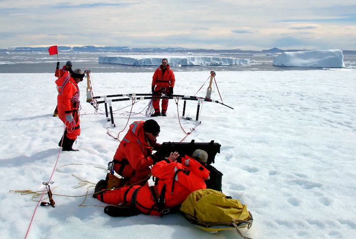 Scientists prepare radar sled on iceberg.