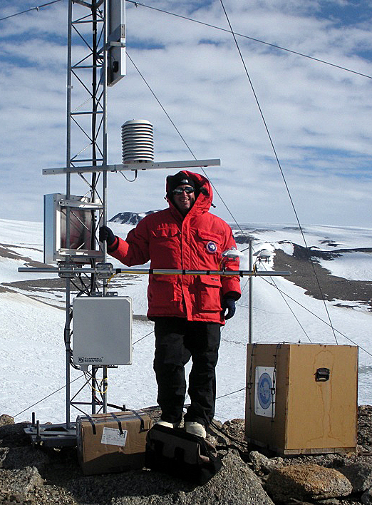 John Cassano next to an Automatic Weather Station.