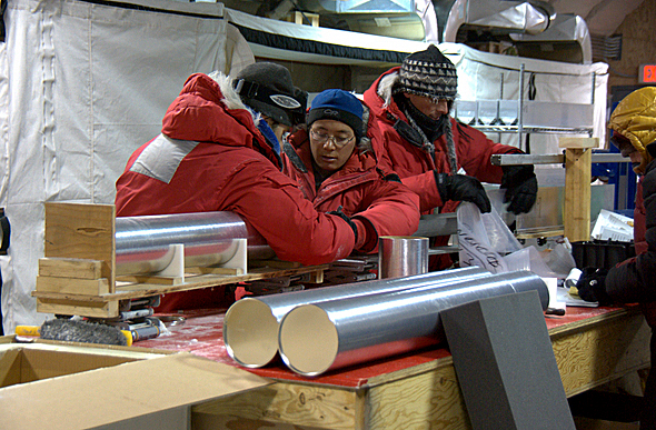People in heavy parkas working at a table.