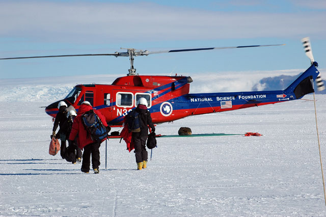 People approach helicopter.