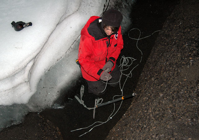 Person works with wire in snow cave.