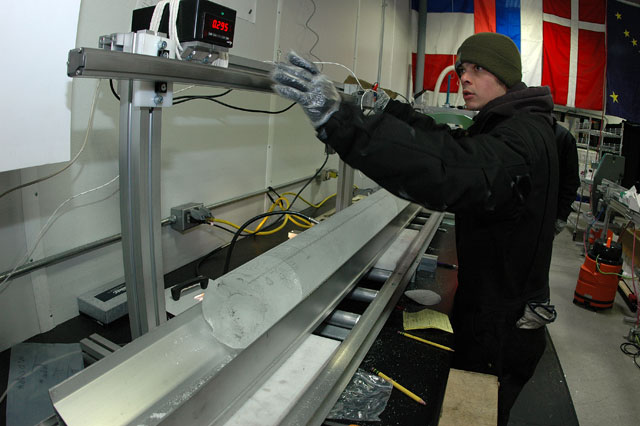 Person operates machine that holds ice core.