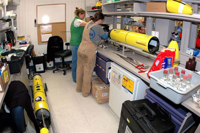 People work on yellow instrument.