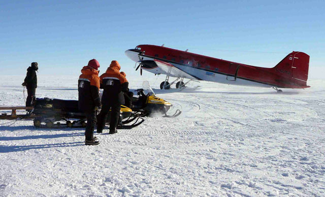 People stand near an aircraft on ice.