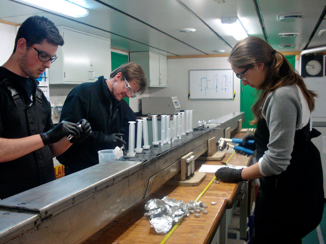 Three people work on sediment core.