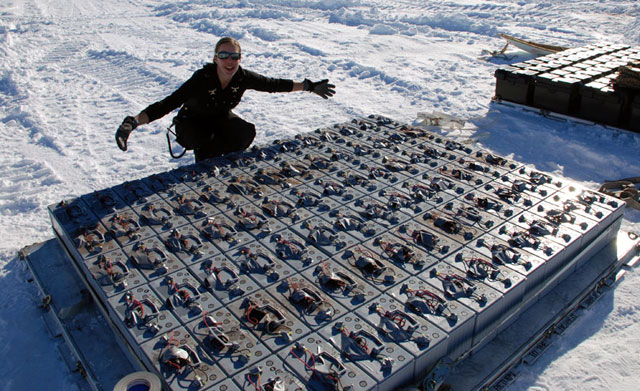 Person displays pallet of batteries.