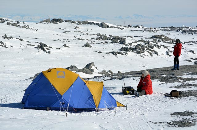 People on a snowy and rocky plain.