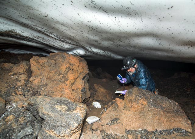 Person explores ice cave.