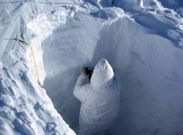 Person stand in snow pit.