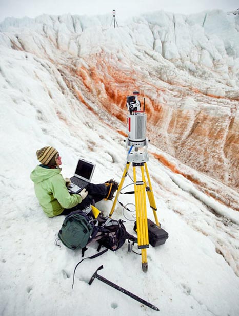 Person with laptop watches tripod.