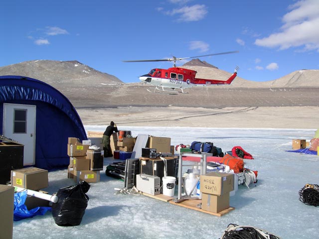 Helicopter approaches camp on ice.