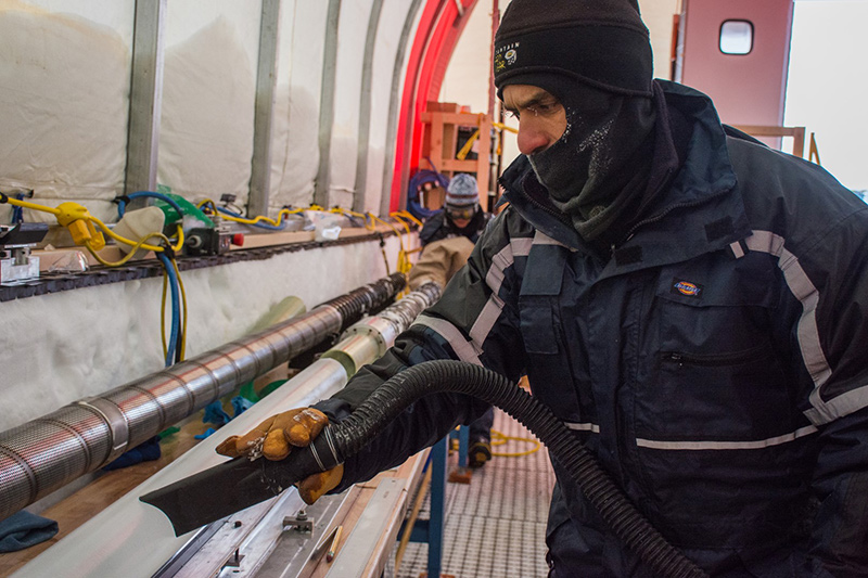 Murat Aydin cleans cutting fluid off of a recent ice core as he prepares it for storage.