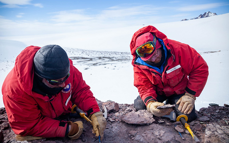 Neil Shubin (left) and Tim Senden examine specimens they pulled from a rocky outcrop.