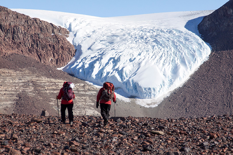 Researchers Allie Belter (left) and Gregory Balco hike towards the Shackleton Glacier spilling over a section of Roberts Massif