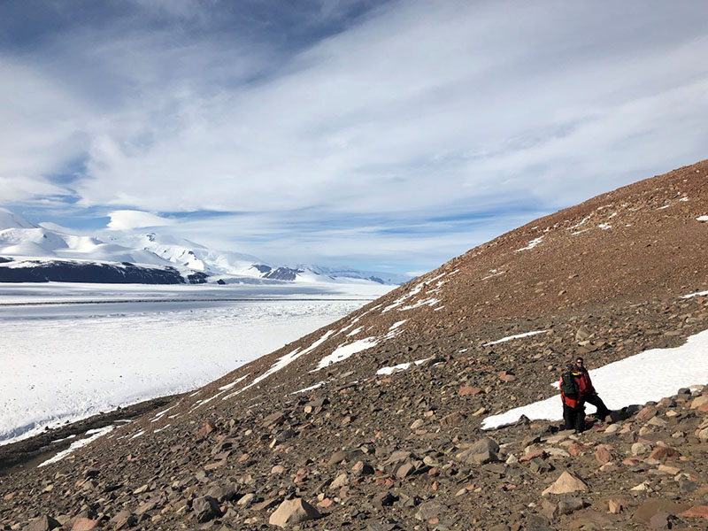Noah Fierer and Diana Wall confer on the side of a mountain in the Transantarctic Mountains