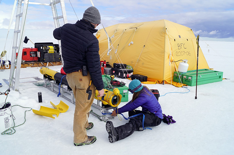 At their field site near the Erebus Ice Tongue, Matt Meister (left) and Tiegan Hobbs prepare the robot to dive under the sea ice to explore under the adjacent ice tongue, a place that had never been explored before.
