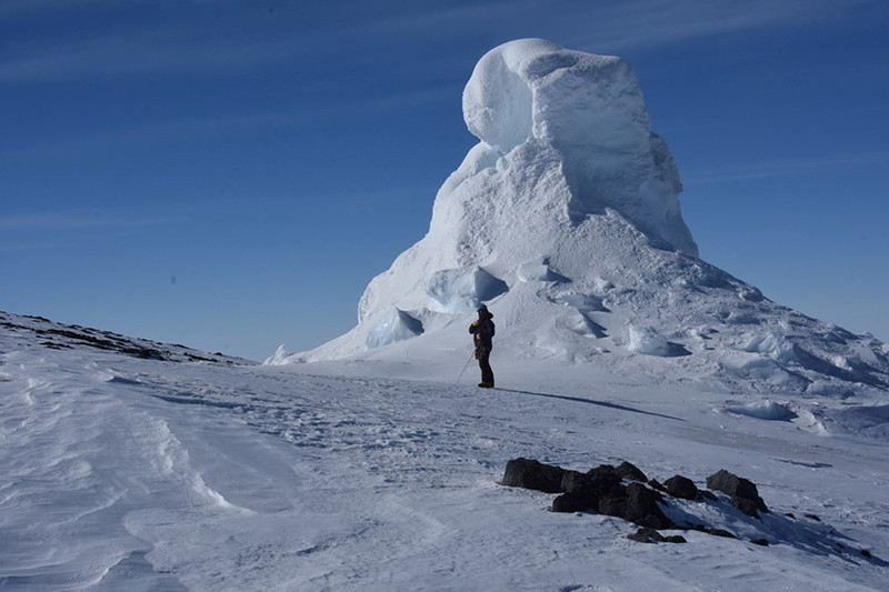 Mountaineer Tom Schaefer stands in front of a fumarole, an ice tower formed when water vapor refreezes into frozen tower