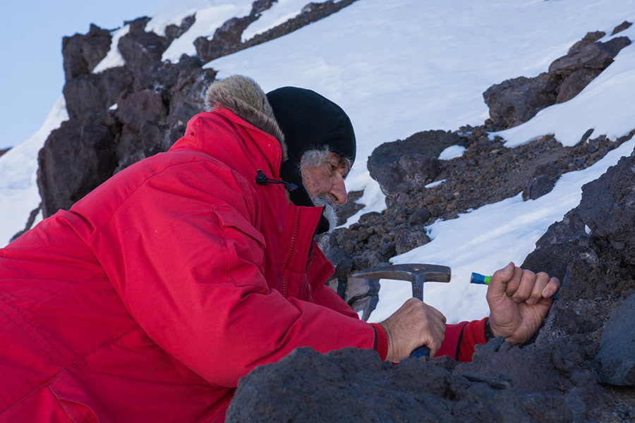 Hubert Staudigel chips off a piece of volcanic rock