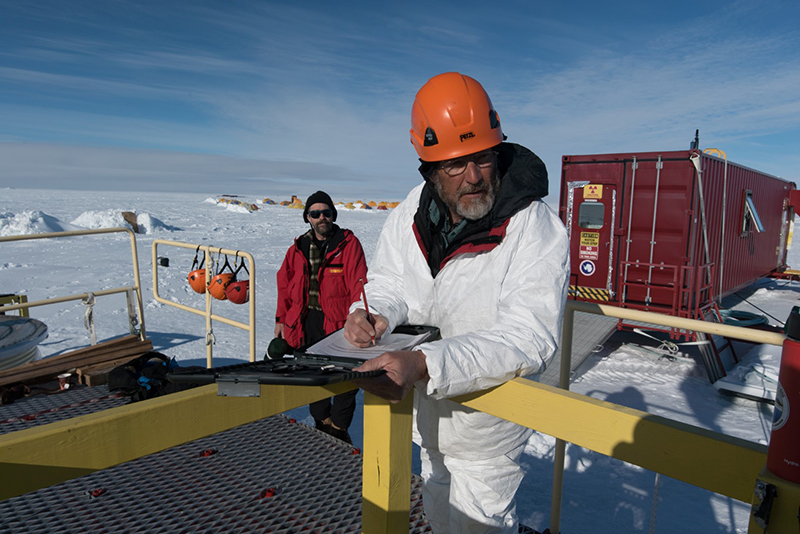 Principal investigator, John Priscu, monitors the drilling of the borehole from the deck of the drill.