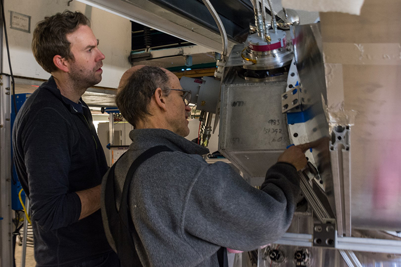 Brad Benson (left) and John Carlstrom inspect the casing surrounding the telescopes soon-to-be-installed cryostat and detector.