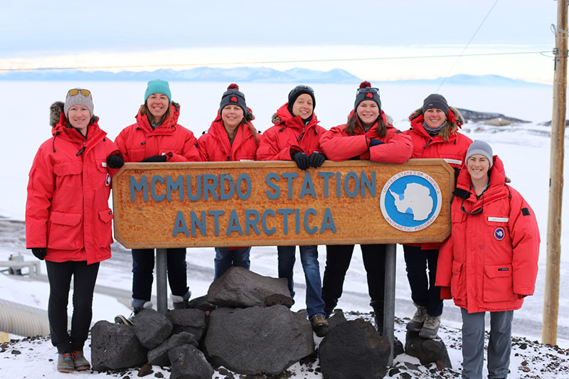 The full seal team poses with the McMurdo Station sign