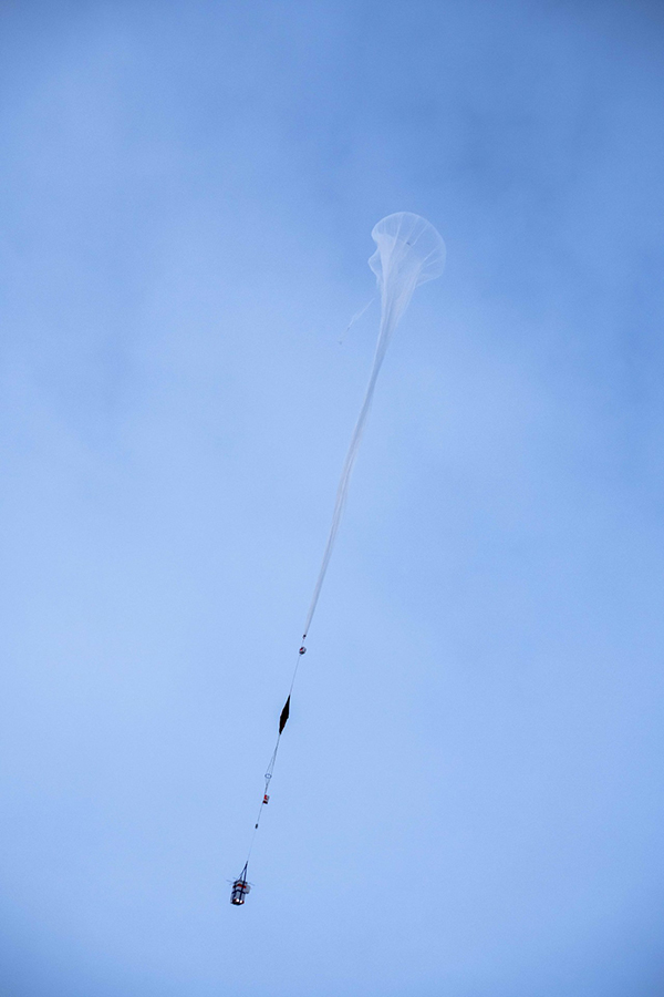 Carried aloft by a helium balloon, the team's particle counters fly into the sky. 