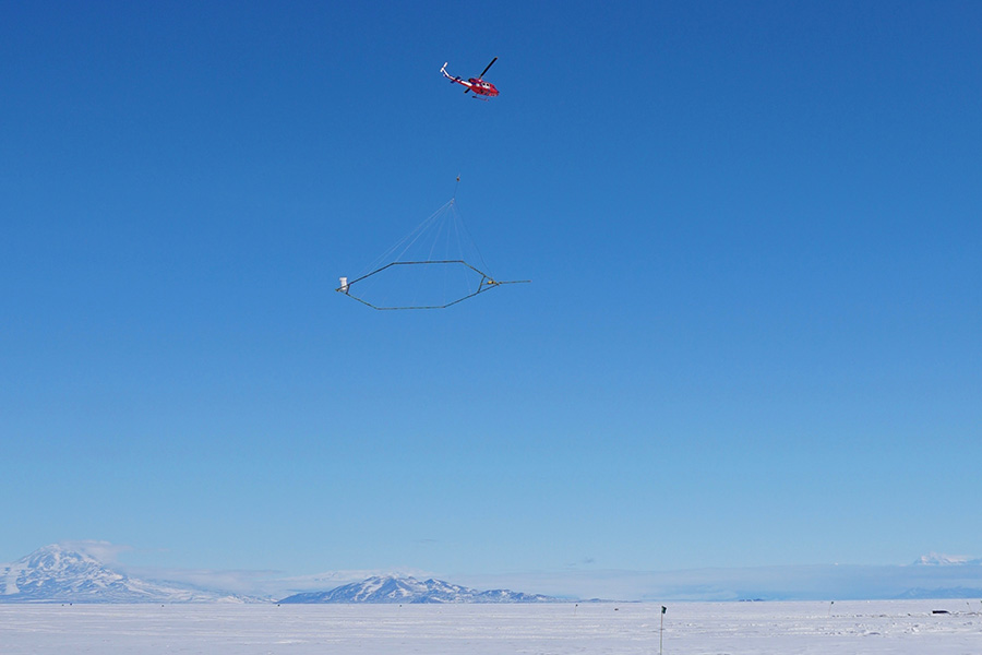 A helicopter crew conducts an airborne electromagnetic survey over Wright Valley in Antarctica. 