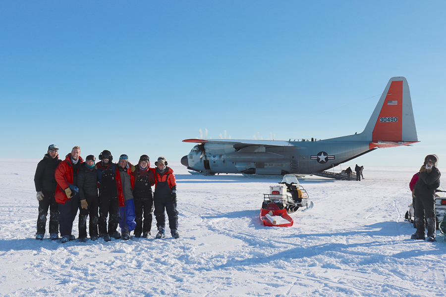 The Hercules Dome field team poses next to a Hercules LC-130 aircraft. From left: Ben Hills, Nick Holschuh, Knut Christianson, John Christian, Andrew Hoffman, Gemma O'Connor, Annika Horlings.