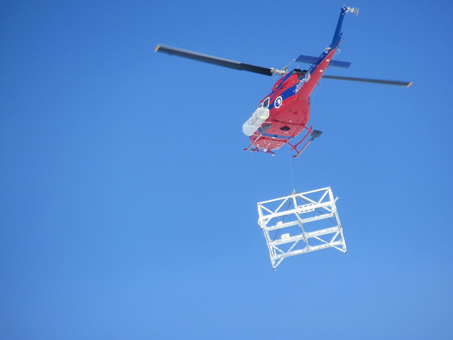 A helicopter lifts the gondola into the air to relocate it to the Basler landing strip.