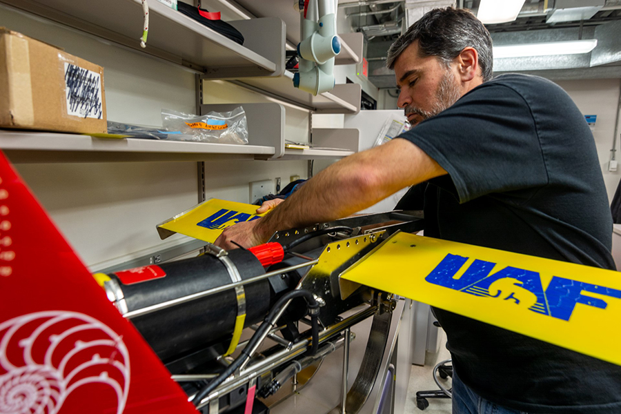 Josh Kohut adjusts an instrument package from the University of Alaska Fairbanks towed behind the boats as they traverse along the Palmer Deep canyon. 