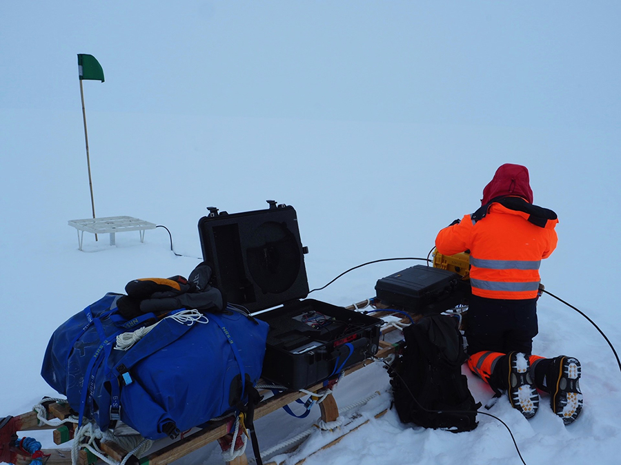 TJ Young takes a measurement of internal ice deformation using a radar along Thwaites Glacier.