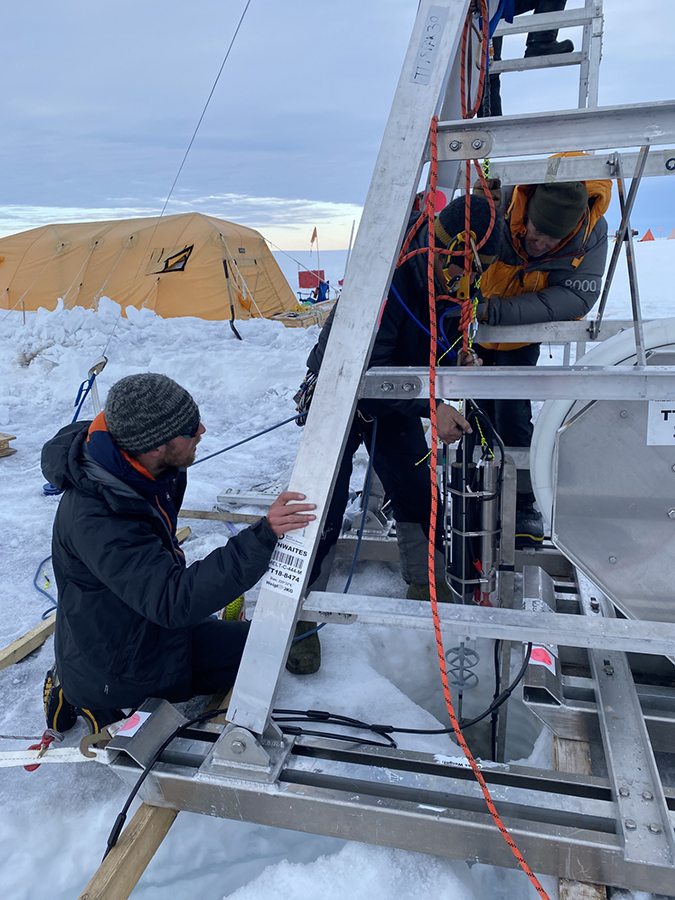 Members of the MELT team deploy an ocean mooring through the ice hole down to the ocean below. The mooring is measuring a range of oceanic conditions to better understand how warm ocean water is melting out the glacier. 