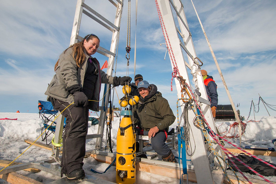 Britney Schmidt (left) and Andy Mullen prepare to lower their autonomous underwater vehicle Icefin down the ice hole into the ocean. 