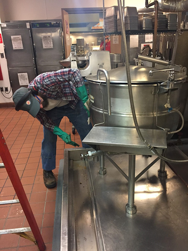 Postal supervisor James Roth pitches in and helps to clean the kitchen following the glycol spill