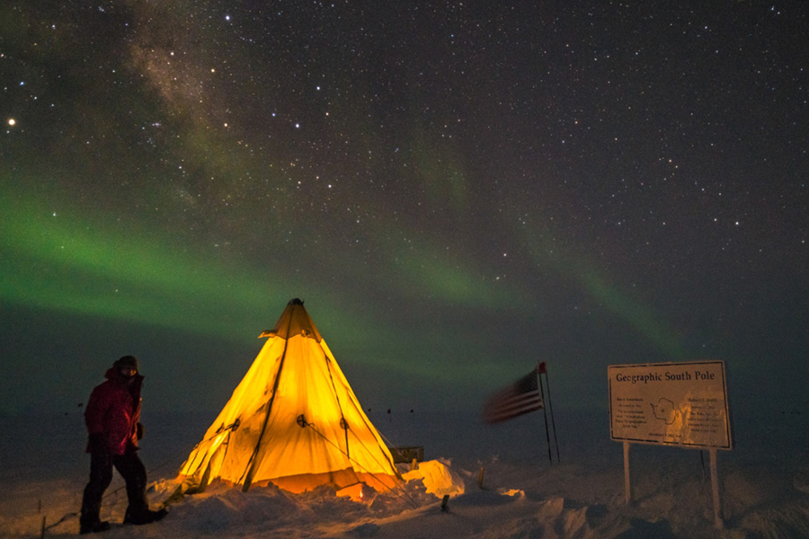 Illuminated from the inside, station residents set up a Scott tent near the geographic south pole, a shelter similar to what the earliest polar explorers used