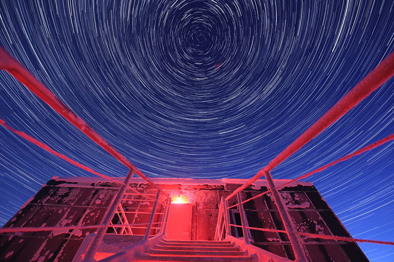 A timelapse photo captures the star trails over one of the rear entrances to the elevated station