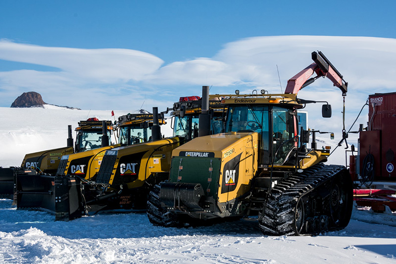 Prior to leaving McMurdo Station, a line of tractors
                            sits parked at the traverse's staging area. The SPoT team is busy making
                            last minute preparations for their imminent departure.