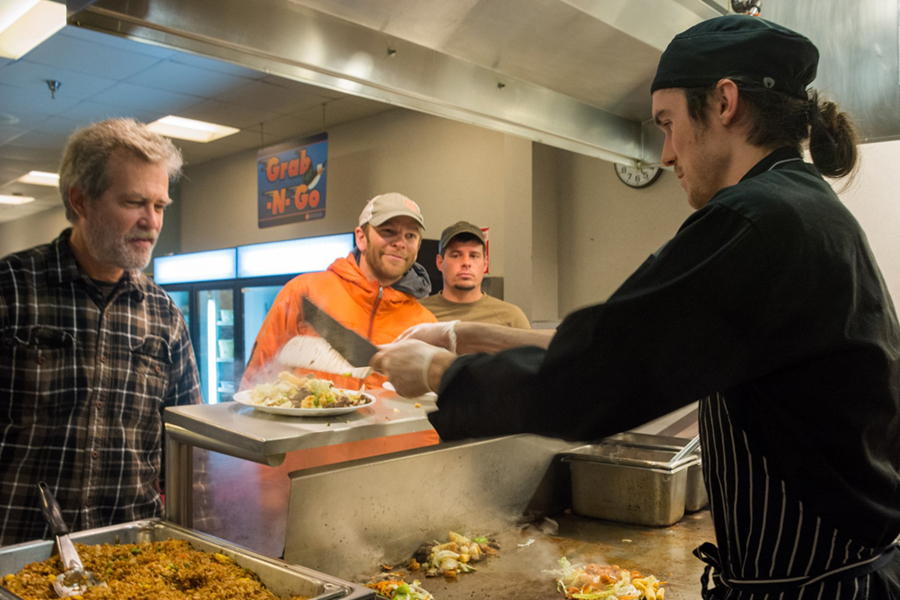 Devin Reid serves up a plate of hot stir fry from the Mongolian Grill action station