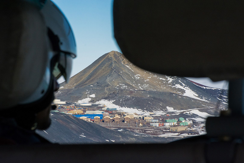 At the end of a long day, McMurdo Station appears up ahead as the helicopter crew returns home