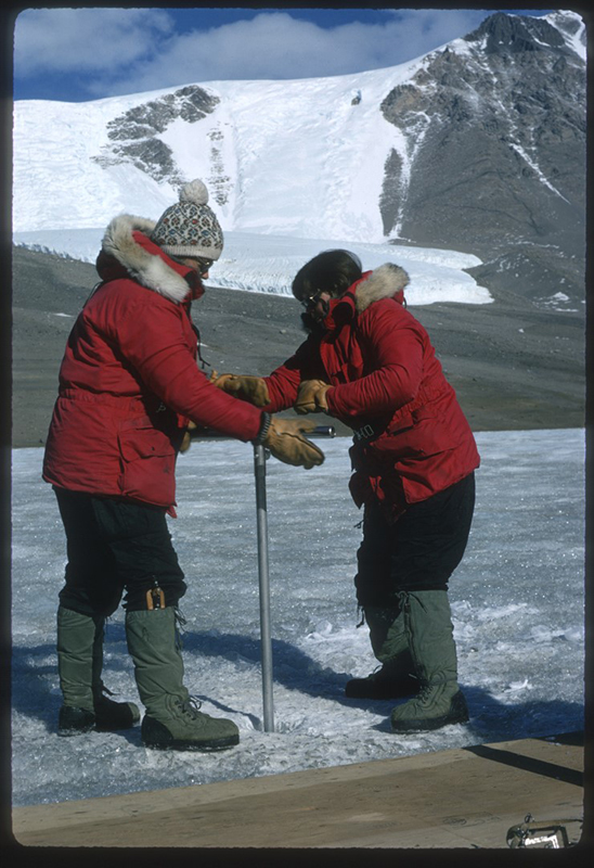 After drilling through 14 feet of ice by hand, Terry Tickhill (left) and Eileen McSaveney lowered a pump down the hole to sample the water underneath the Lake Bonney ice. They were examining chemical evidence of rock weathering in the lake.