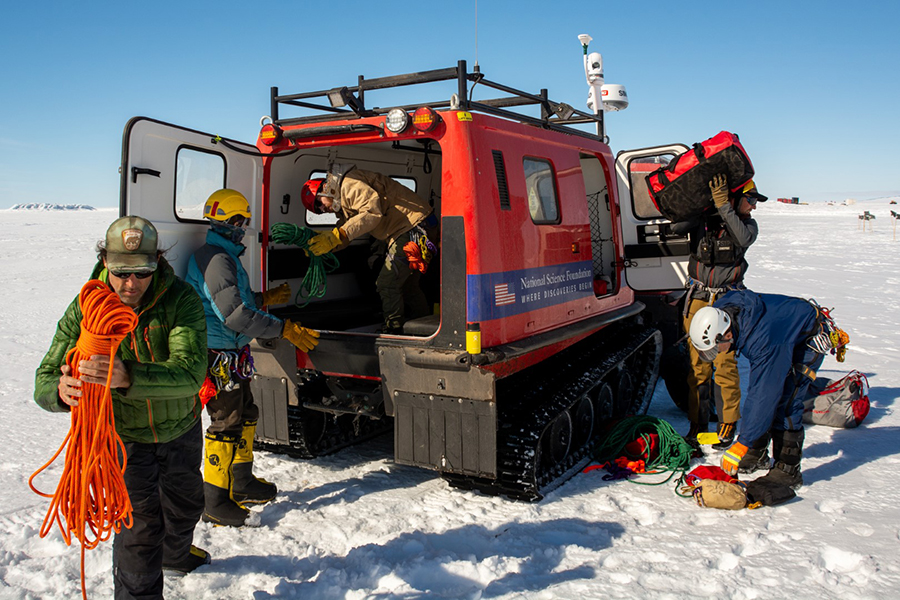 At the crevasse simulator SAR team members (left to right) Federico Piola, Christina Bovinette, Peter Pankowsky, Mitch Beres and John Loomis pull rescue equipment out of a tracked Hägglund.